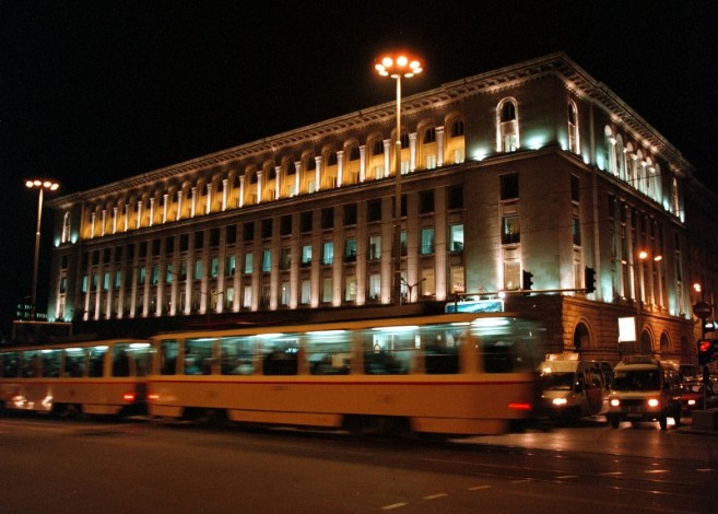 Night view of the exterior of the Tzum Building wuth tram in foreground
